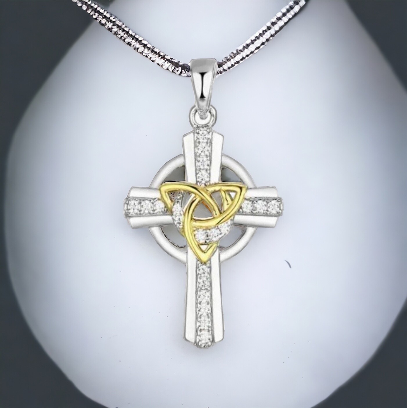 Sterling Silver Celtic Cross with CZ sparkling stones and central yellow gold plated trinity knot. 