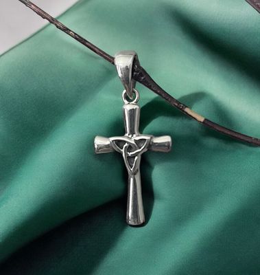 Silver Cross with Central Trinity Knot Sterling Silver Celtic Cross with Central Trinity Knot on Green Fabric.