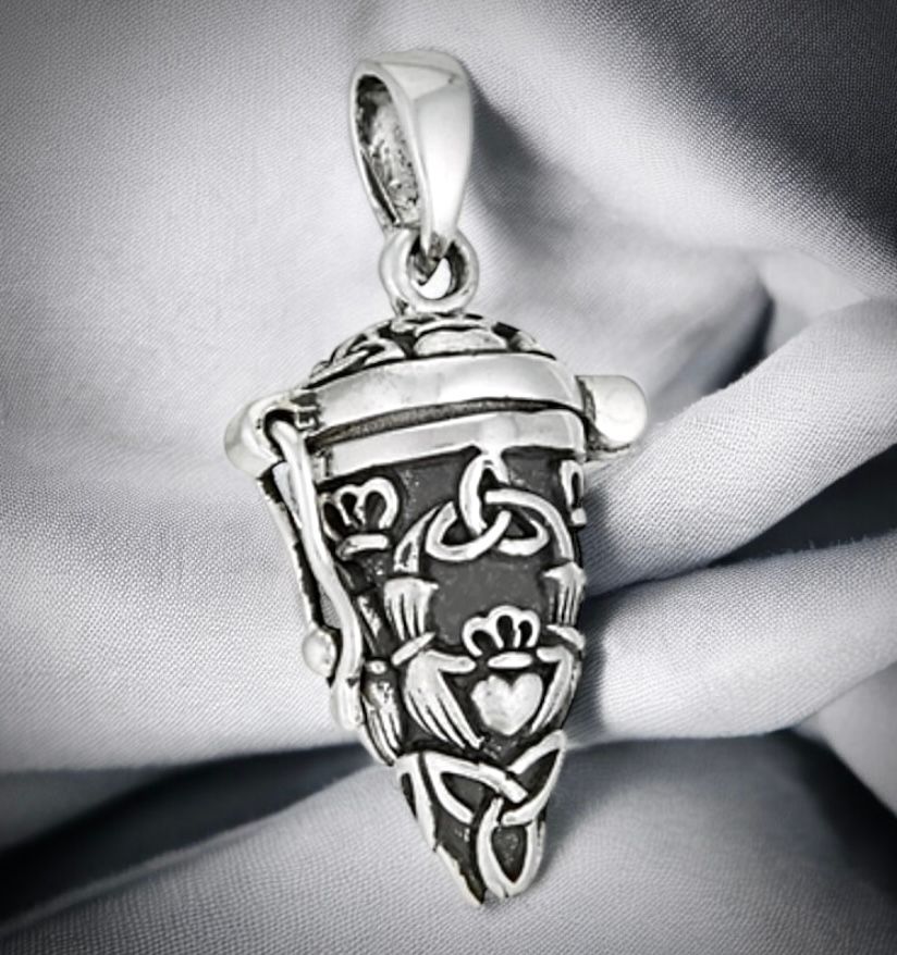 Sterling silver vial locket pendant necklace with Celtic trinity knot design, handcrafted jewelry, on grey fabric.