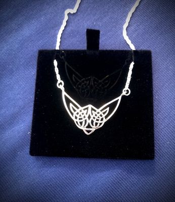 Highland Cow Necklet, Celebrate Scotland! Sterling silver Highland Cow necklet, celebrating Scottish heritage and Celtic design, shown on black jewelry holder.