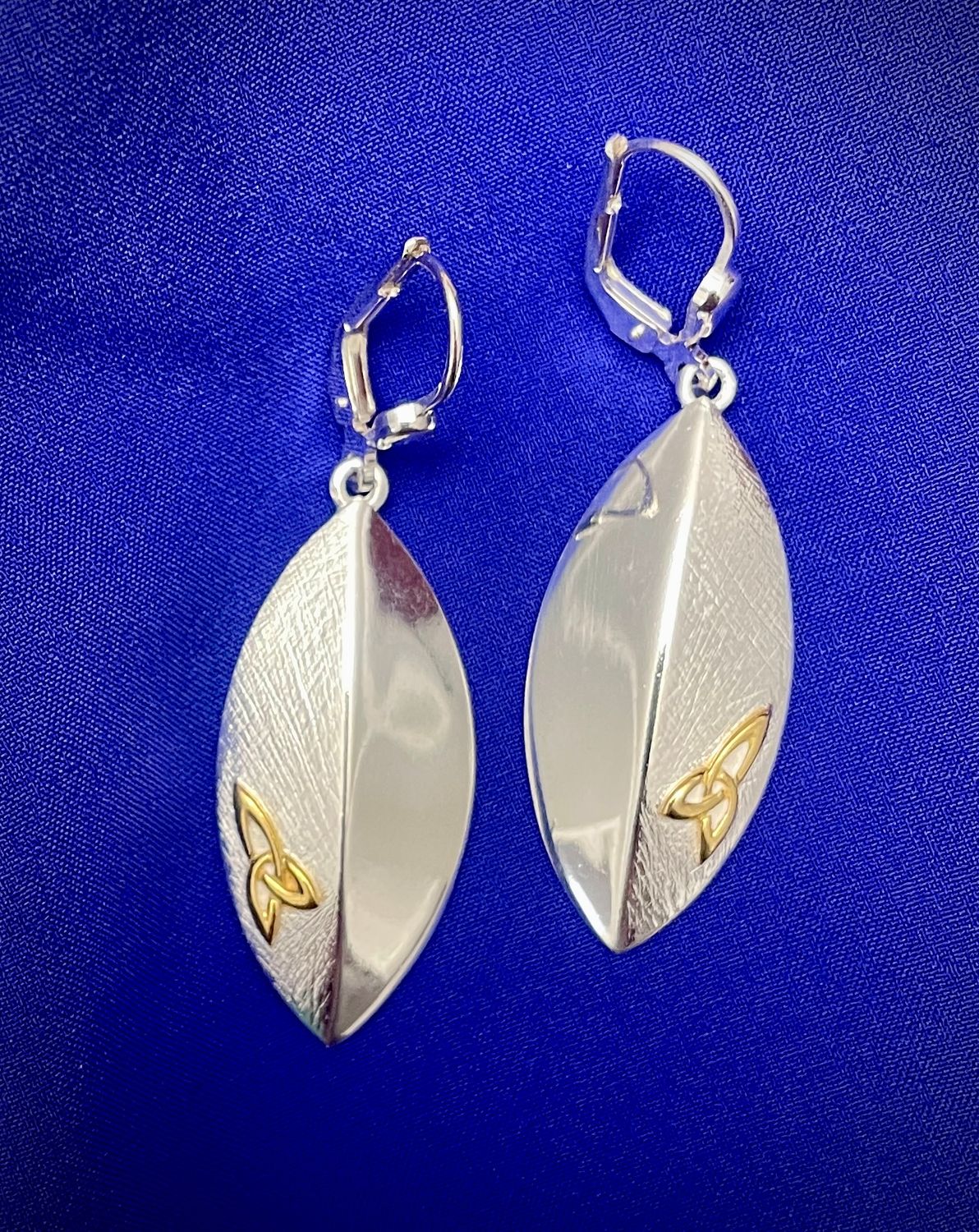 Trinity Knot Shield Earrings Handcrafted silver shield earrings with intricate raised Trinity Knot detailing, inspired by Celtic heritage.