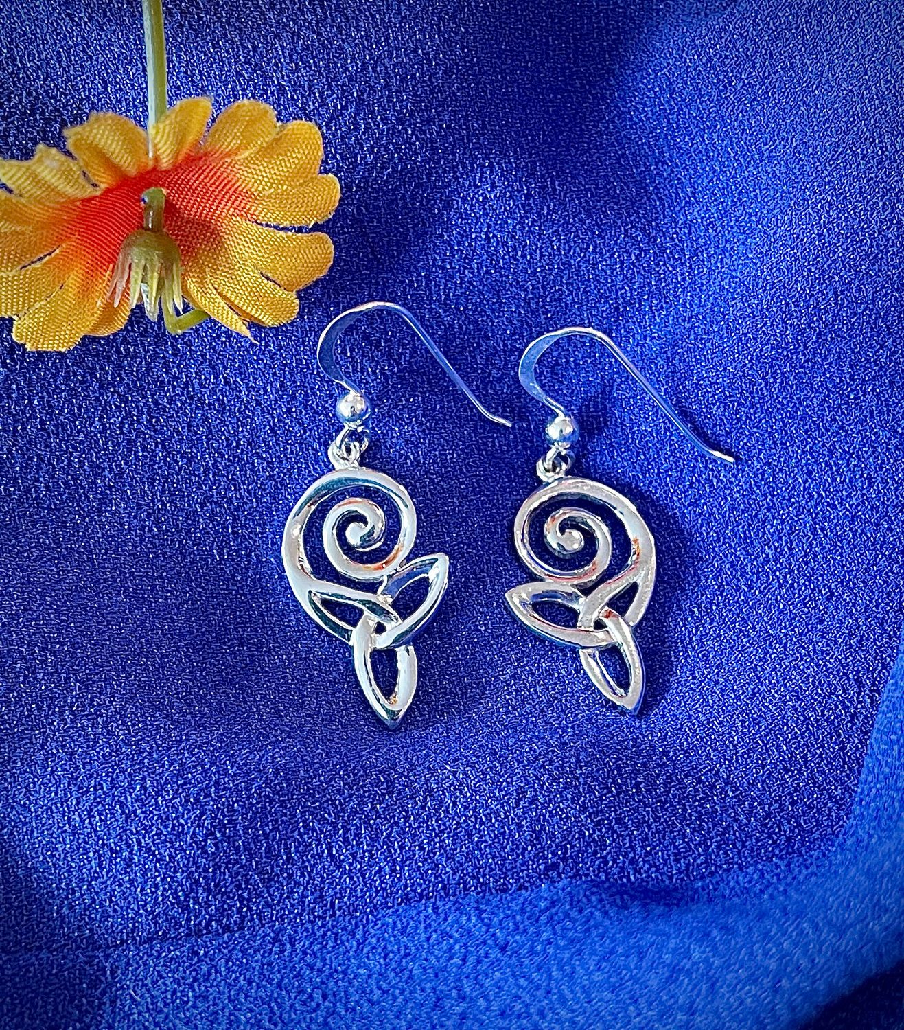 Trinity Knot Silver Swirl Earrings Sterling Silver Celtic Swirl Drop Earrings on Blue Background