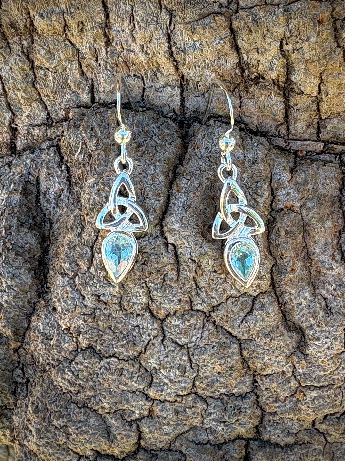 Sterling silver Trinity Knot earrings with blue topaz December birthstones, Celtic jewelry symbolizing unity.