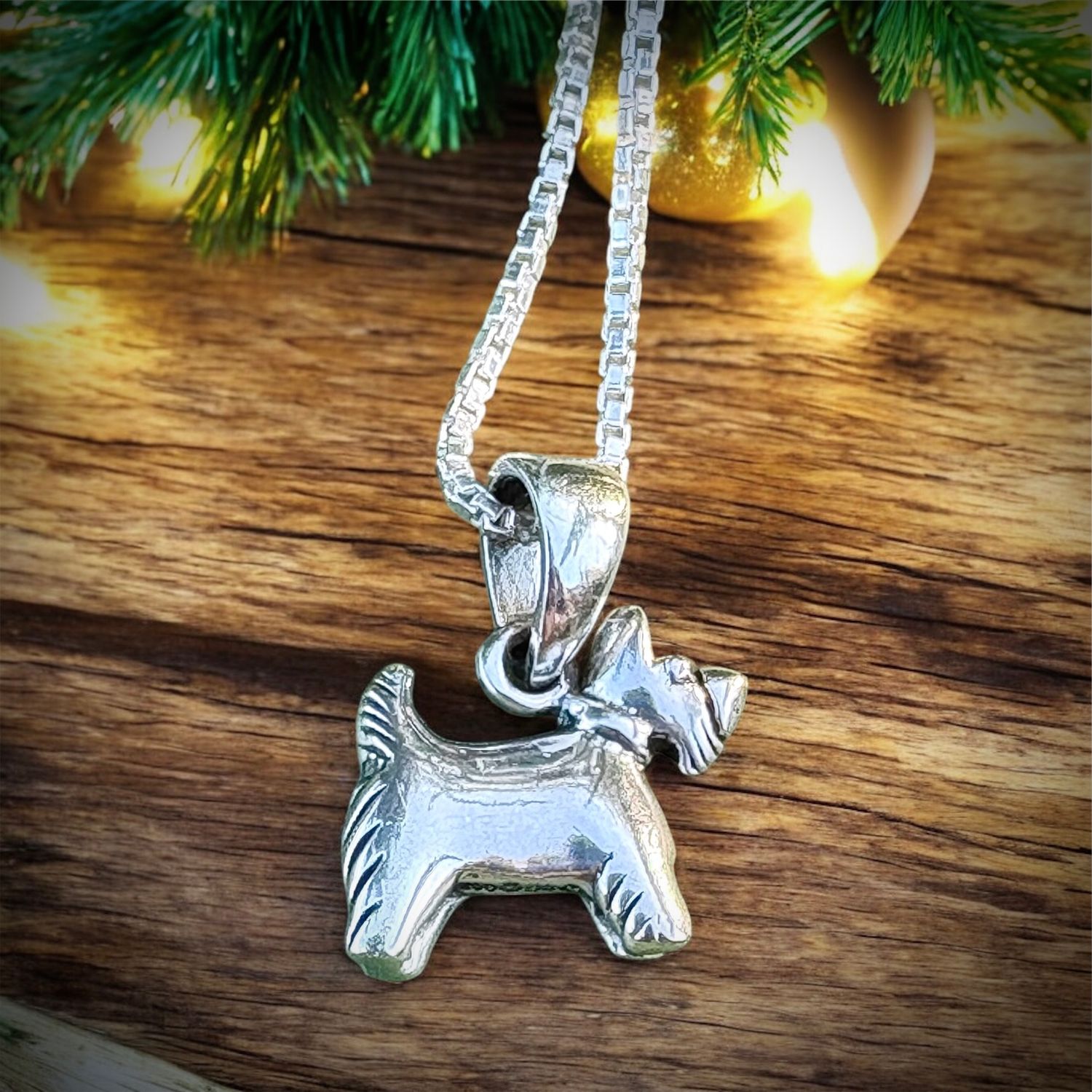 Sterling silver Scottish Terrier pendant necklace, handcrafted Scottie dog charm jewelry near holiday lights. 